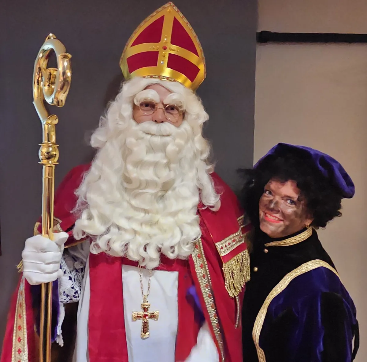 Sinterklaas met staf naast Piet